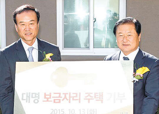 박흥석 대명그룹 총괄사장(왼쪽)과 노승락 홍천군수가 보금자리주택 준공식과 열쇠 전달식에서 기념촬영을 하고 있다.         대명그룹 제공